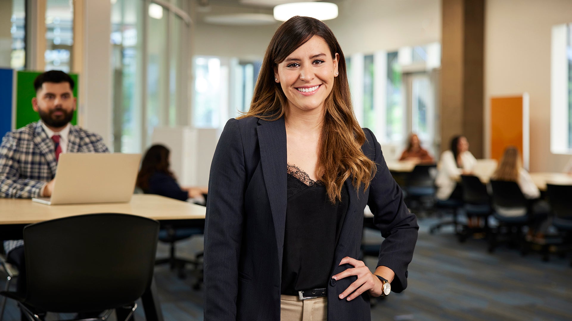 Image of a Graduate Degree student in a blazer smiling with her hand on her hip in a classroom in Thunderbird School of Global Management's new Global Headquarters.
