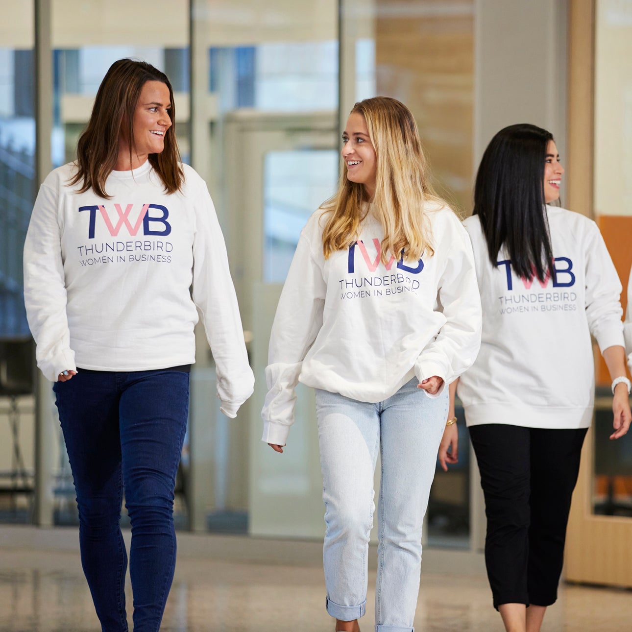 A group of women from Thunderbird's Women in Business club walking and smiling at Thunderbird School of Global Management's new Global Headquarters.