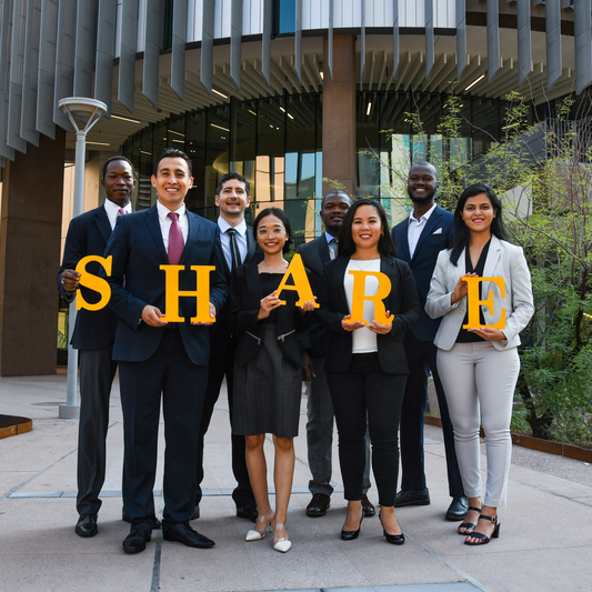 Group image of share fellows holding Thunderbird gold letters that spell SHARE outside Thunderbird School of Global Management's new Global Headquarters.