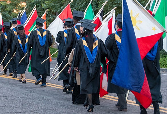 Image of Thunderbird graduates carrying their country's flags in the flag ceremony