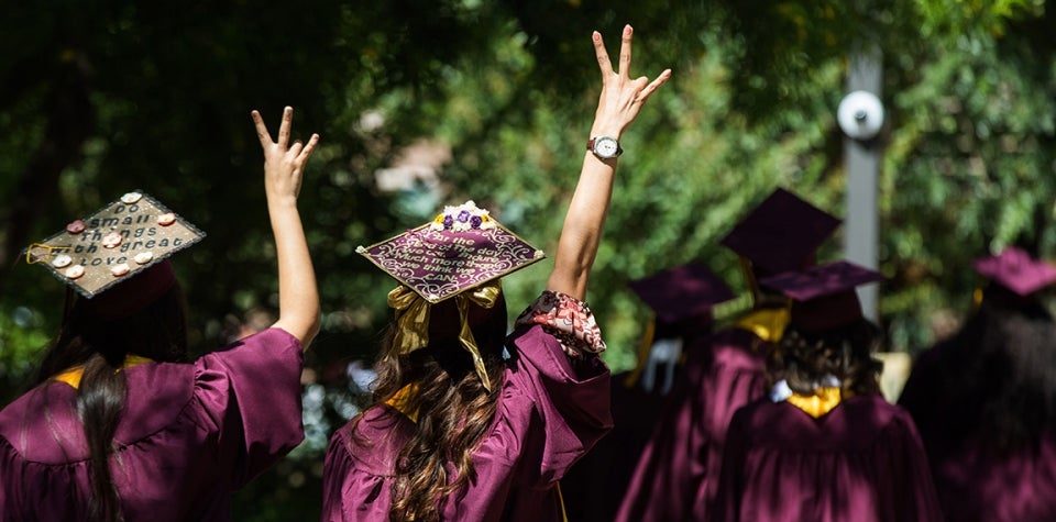 Students in robes celebrate their graduation at the ASU West Campus