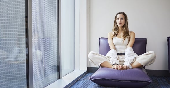 Image of a graduate student sitting on a pillow in Thunderbird School of Global Management's meditation room in the new Global Headquarters.
