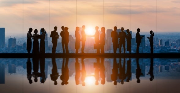 Group of business people in front of a window overlooking city