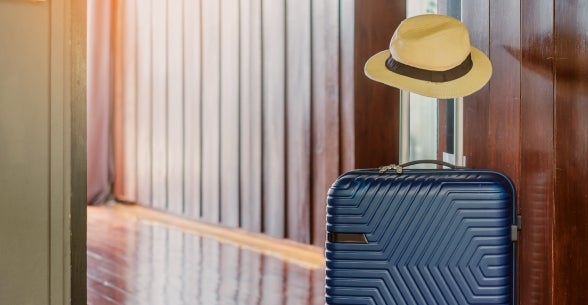 Suitcase and travel hat representing leisure and hospitality segment