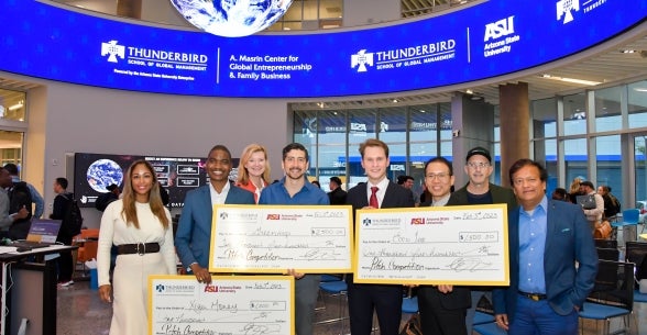 Image of the winners of the Pitch competition holding their checks.