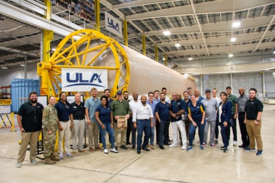 Image of Thunderbird students in the Space Leadership program standing by a rocket during a site visit.