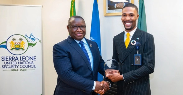 His Excellency, Julius Maada, president of the Republic of Sierra Leone, presents Isaac Sheku Bayoh with an award for outstanding service.